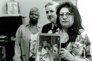 Blanca Bosquez holds a picture of her son while at a meeting with her son’s public defender, Ross McMahon, and De-Bug organizer, Gail Noble. Photo by Charisse Domingo.